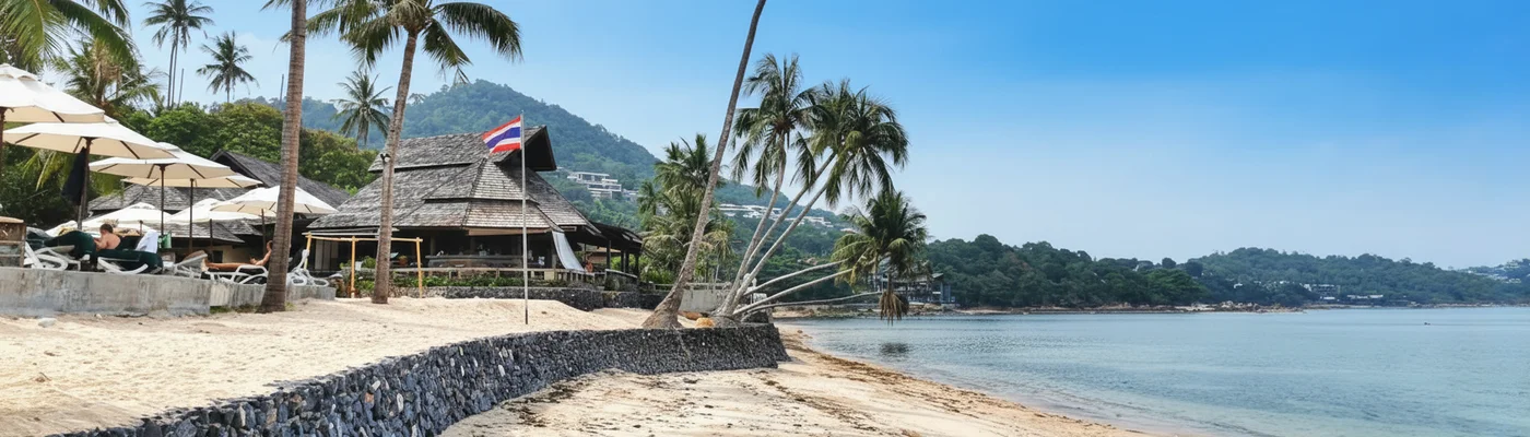 Strand in Thailand ohne Wellen mit Bergen im Hintergrund